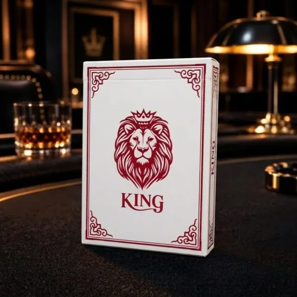 קלפי פוקר מקצועיים KING בגוון אדום — חפיסה עומדת על שולחן פוקר, גב הקלף עם עיטור אריה